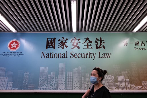 Uma mulher passa por um cartaz da Lei de SeguranÃ§a Nacional em Hong Kong em 28 de julho de 2020.