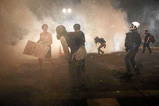 Manifestantes envoltos em nuvem de gÃ¡s lacrimogÃªneo, no centro de Portland