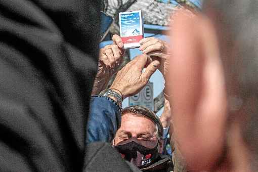 Bolsonaro exibe a caixa do remÃ©dio, como um trofÃ©u, aos apoiadores que foram recebÃª-lo na cidade gaÃºcha